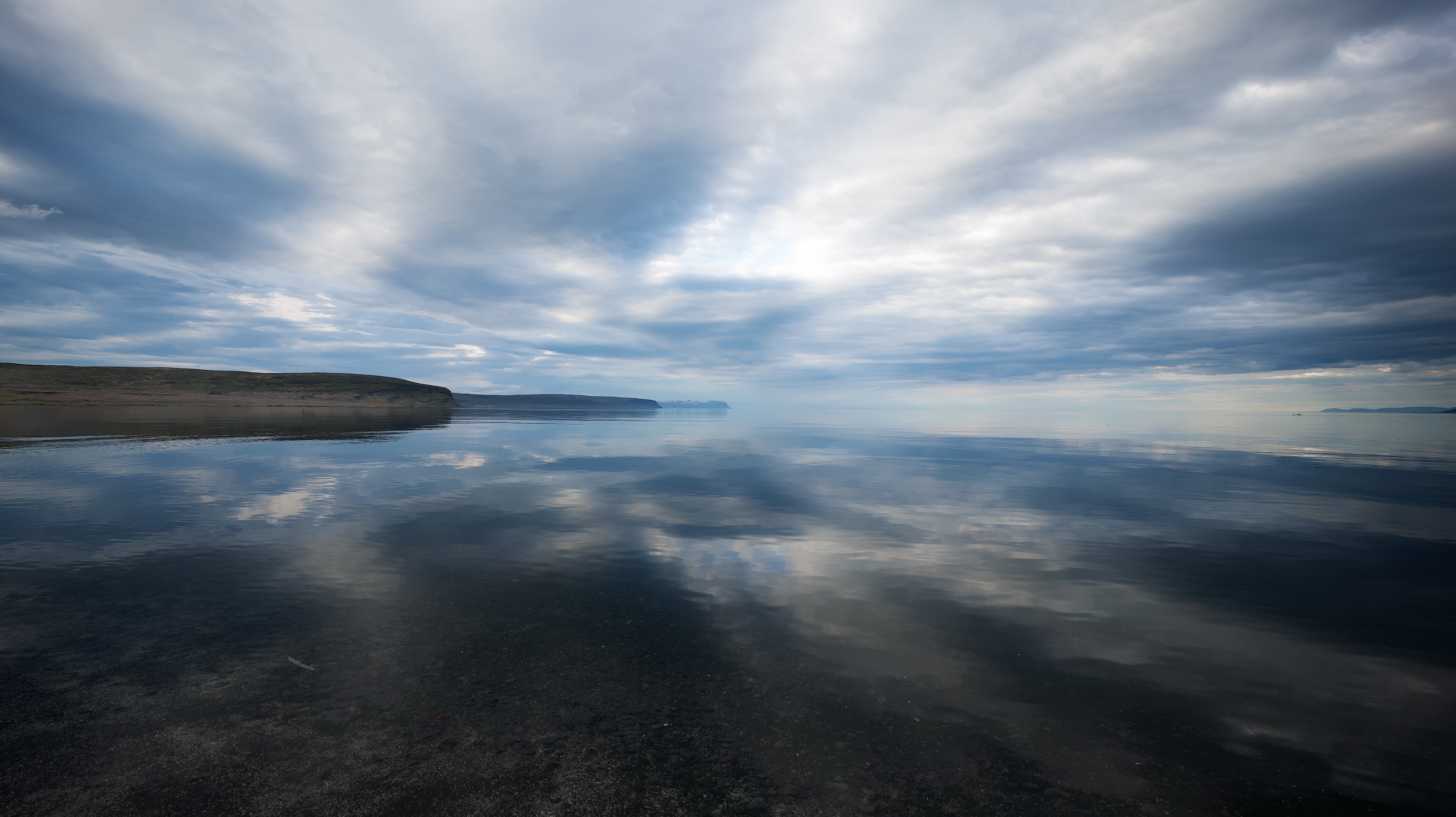 Clouds reflected on a calm sea on the north coast of iceland